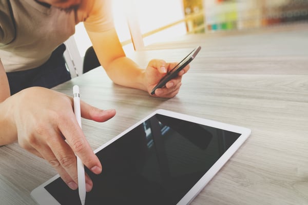 top view of Designer hand working with digital tablet computer and smart phone on wooden desk as responsive web design concept-1