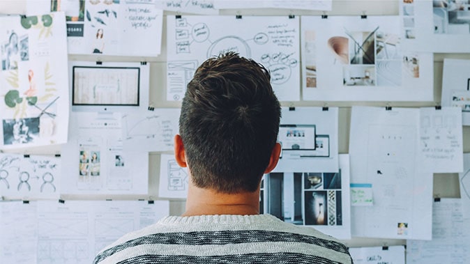 A Man Looking At A Marketing Board